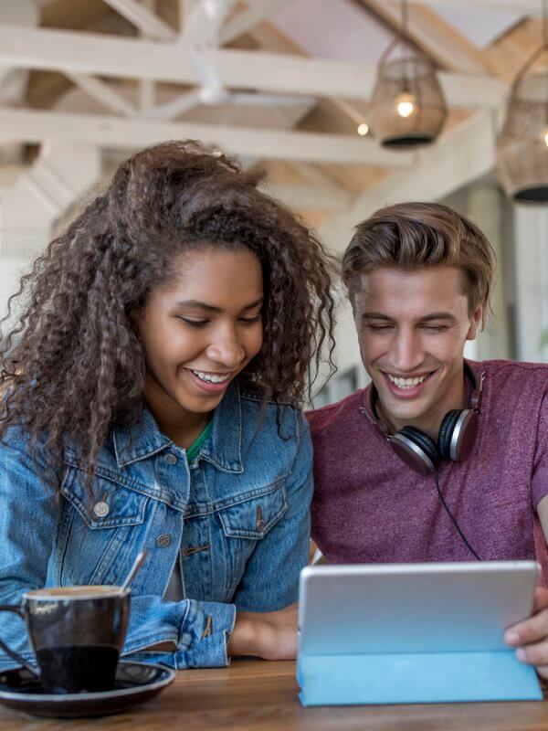Young couple smiling while using a tablet