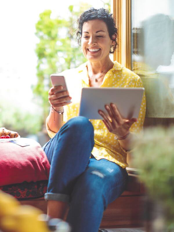 Woman at home using two devices
