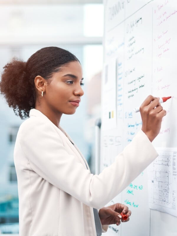 Woman writing on a whiteboard during a meeting