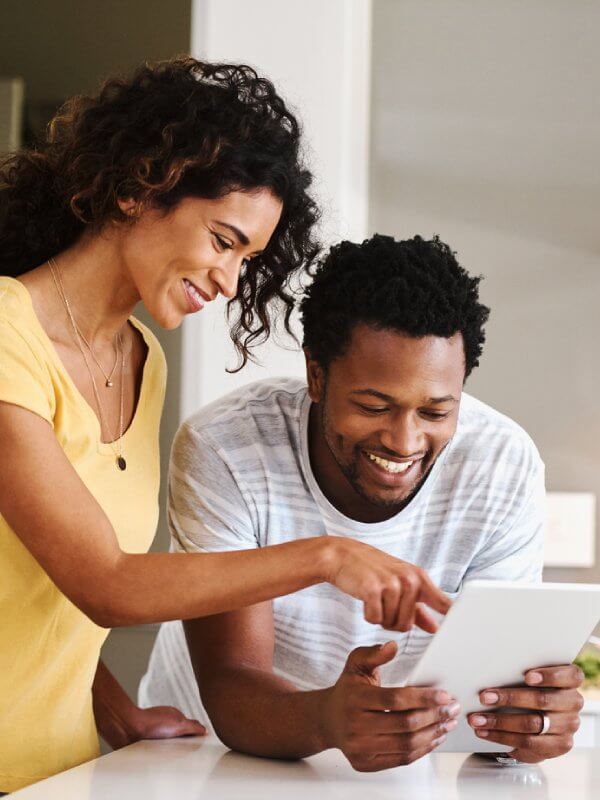 A couple smiling while browsing online