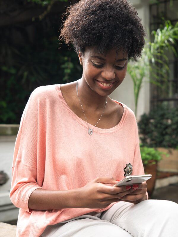 Woman smiling while reading her phone