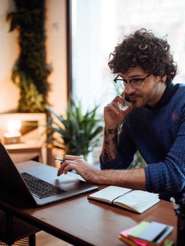 Man working on his laptop and phone