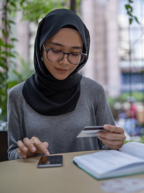 Woman using her phone to enter her bank details