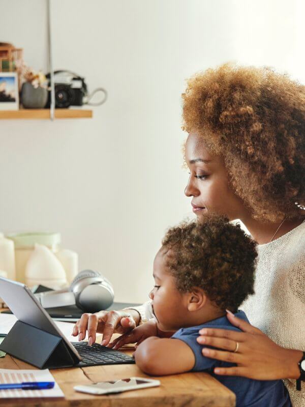 Mother and her child on laptop in the kitchen