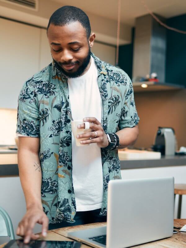 Man in kitchen browsing at data on a tablet