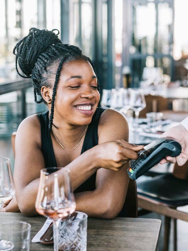 Young woman using her credit card to pay a restaurant bill