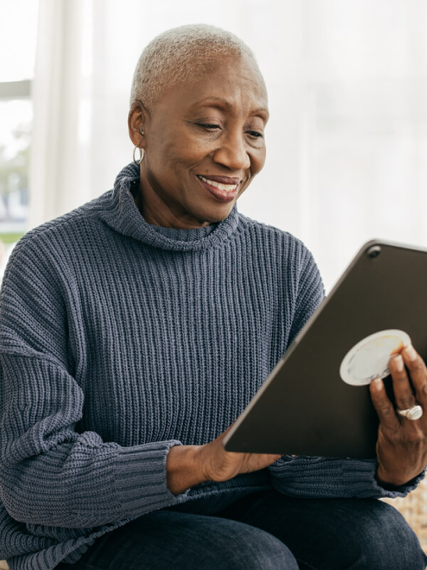 Woman smiling while browsing on tablet