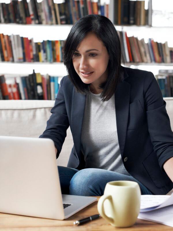 Woman using a laptop to understand the credit risk of her customers