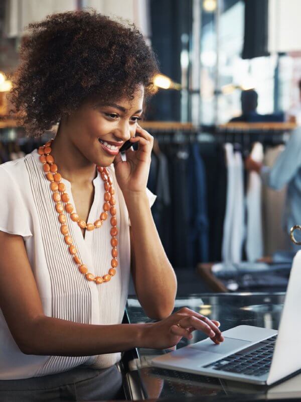 Business owner looking at her database on a laptop