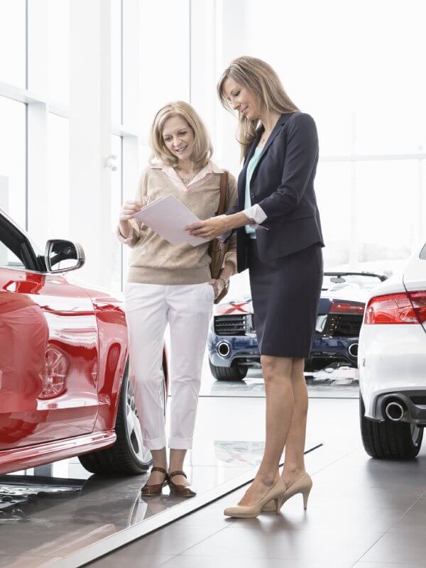 Car saleswoman giving a prospective customer more information