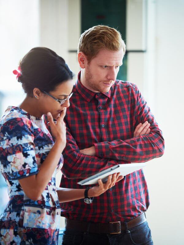 Two colleagues looking at data on a tablet