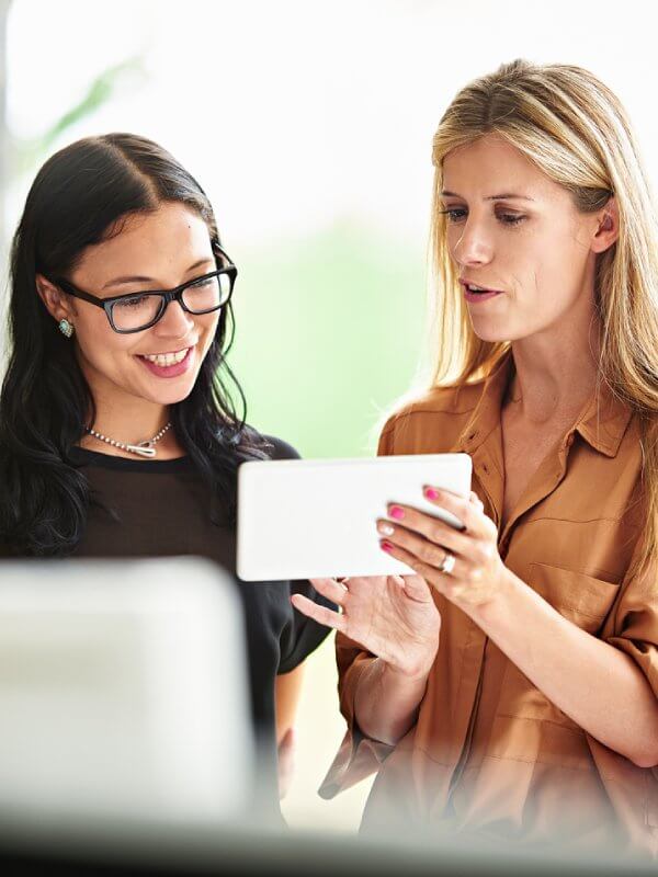 Two colleagues looking at data on a tablet