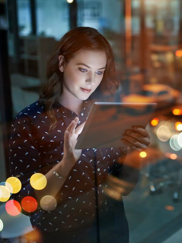 Woman at work assessing data on her tablet