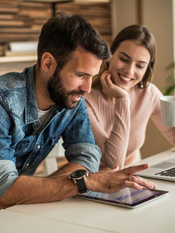 Two colleagues looking at data on a tablet