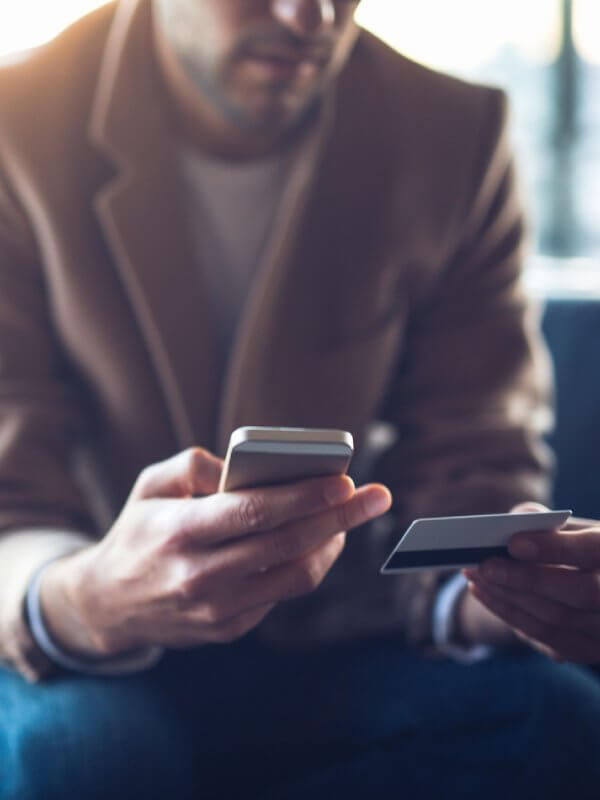 Man trying to use a credit card with his mobile phone