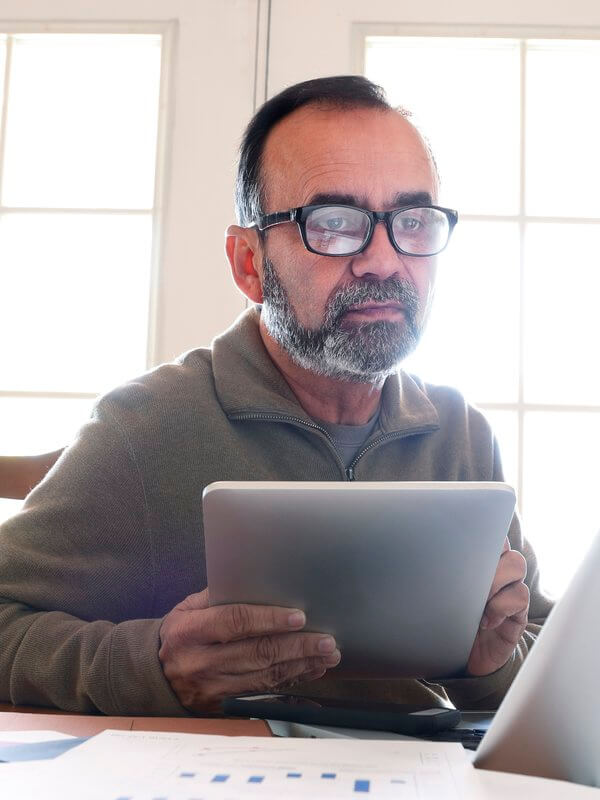 Man sending a text while working