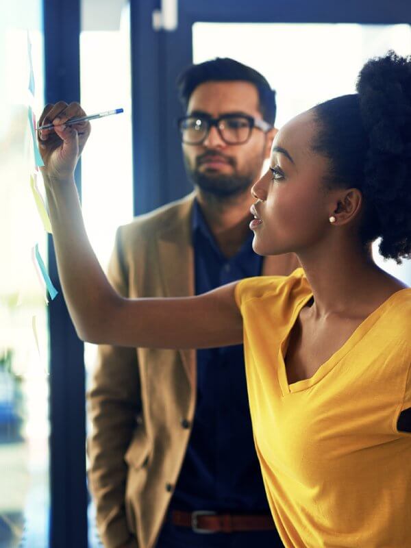 Woman writing on a whiteboard during a meeting