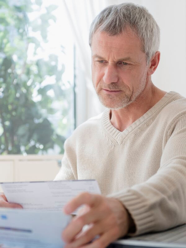 A mature man looking at utility bills