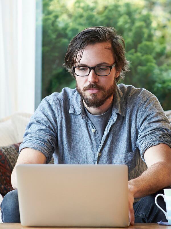 Man applying for a job at home on his laptop