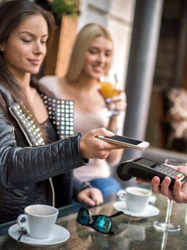 Woman paying for drinks in a cafe