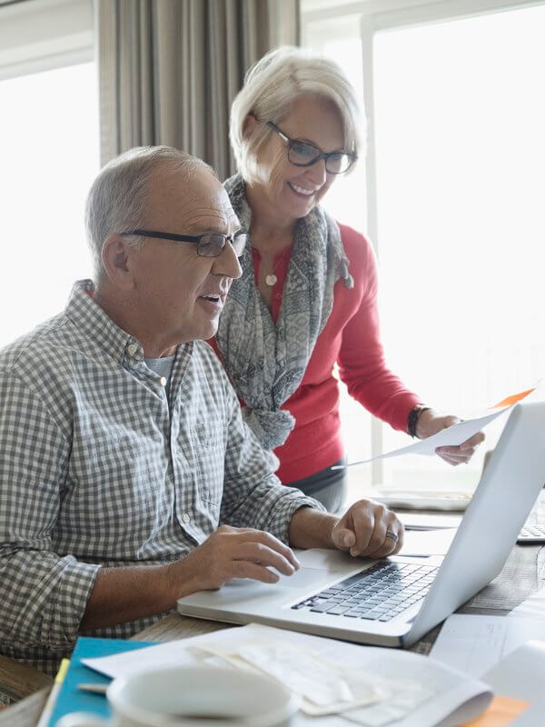 Mature couple entering their address details into their laptop