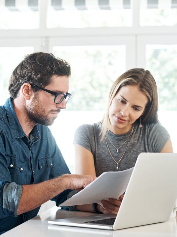 Two colleagues looking at data on a laptop