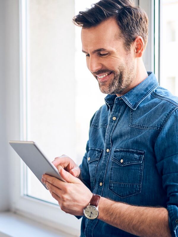 Man using his tablet device to build once for efficiency