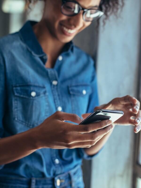 Woman smiling while using her mobile phone
