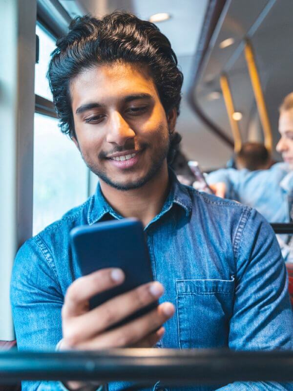 Man looking at phone while on bus