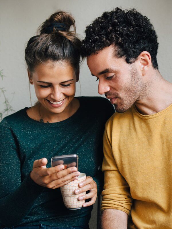 Couple at home applying for credit on a mobile phone
