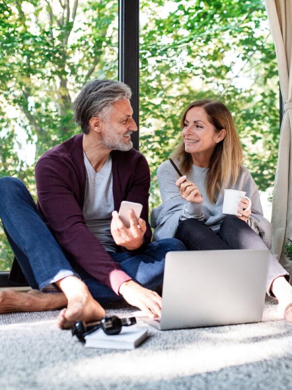 A couple talking while browsing on a laptop