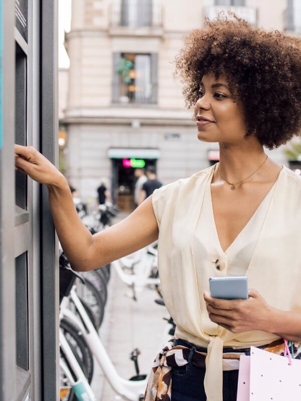 Young woman taking out cash in a different country