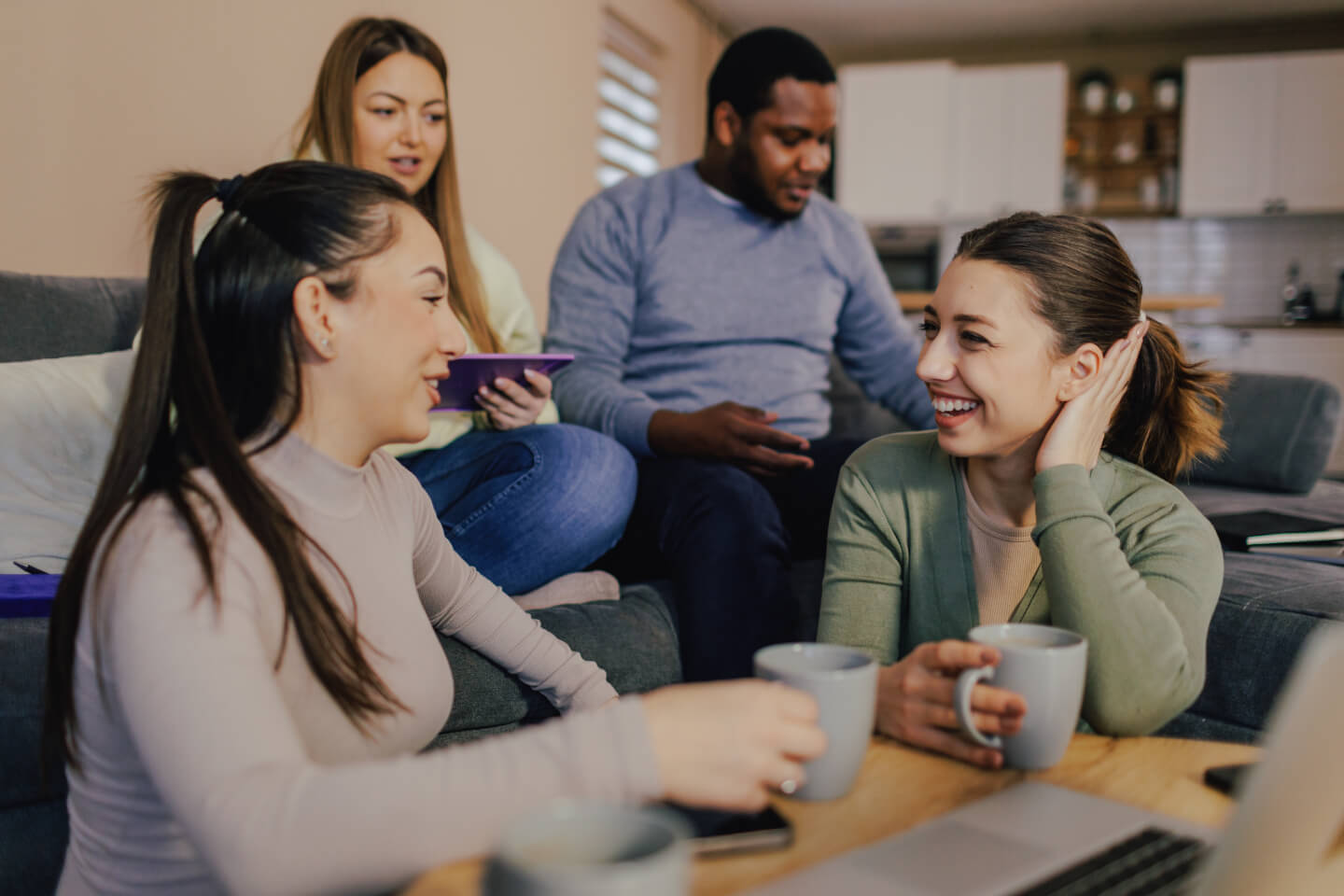 Group of young adults sat around a coffee table