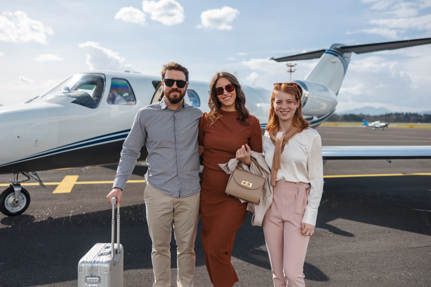Family of three standing in front of a plane