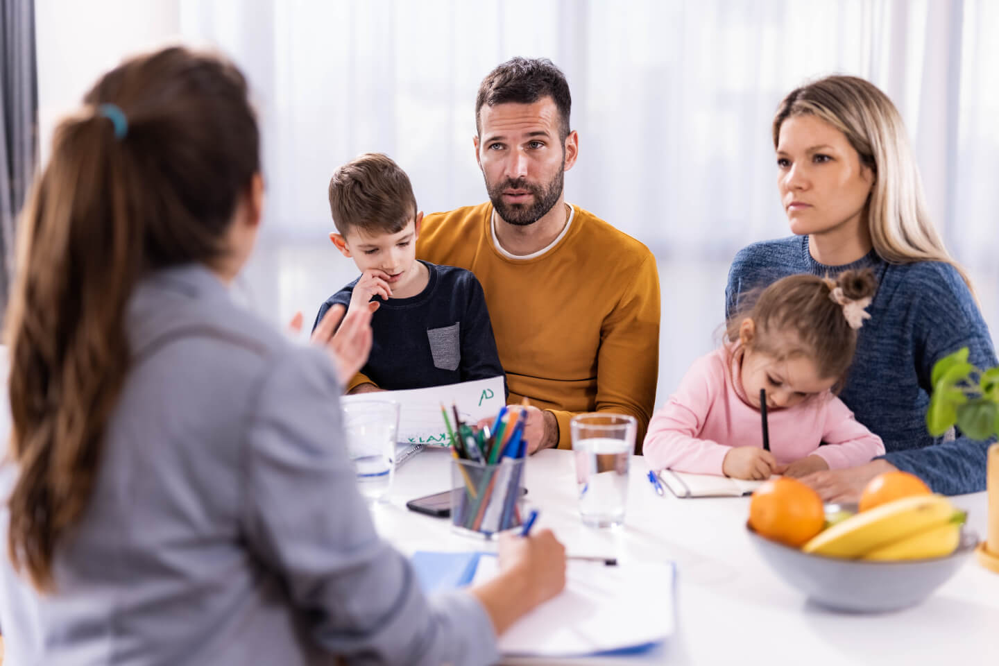 Couple and two young children speaking to an advisor